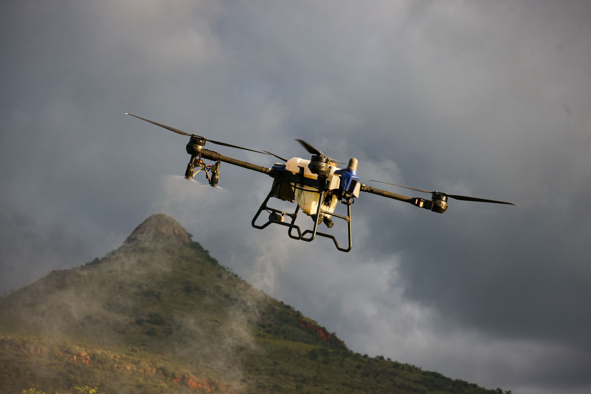 Small folding mapping drone flying a grid pattern over open farmland